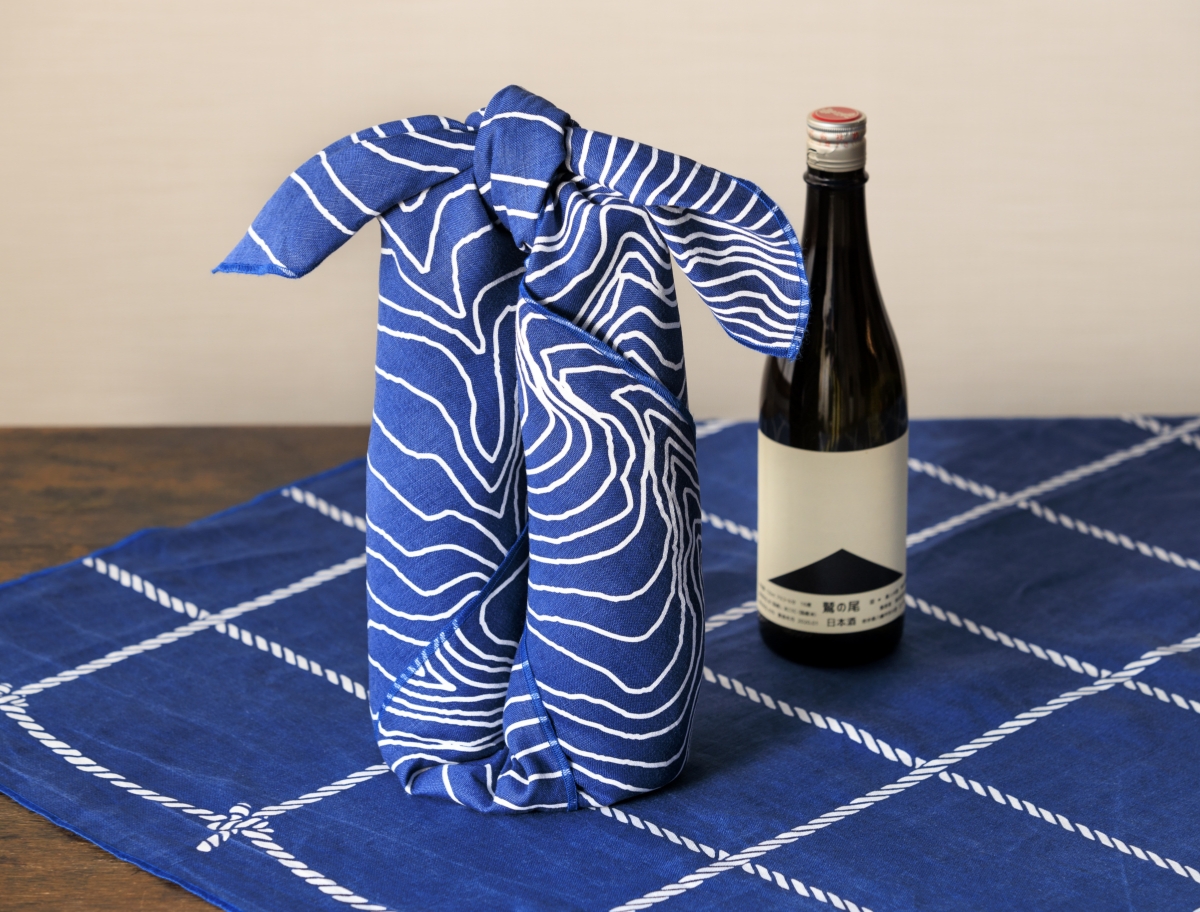 風呂敷で酒を包んでいる様子
